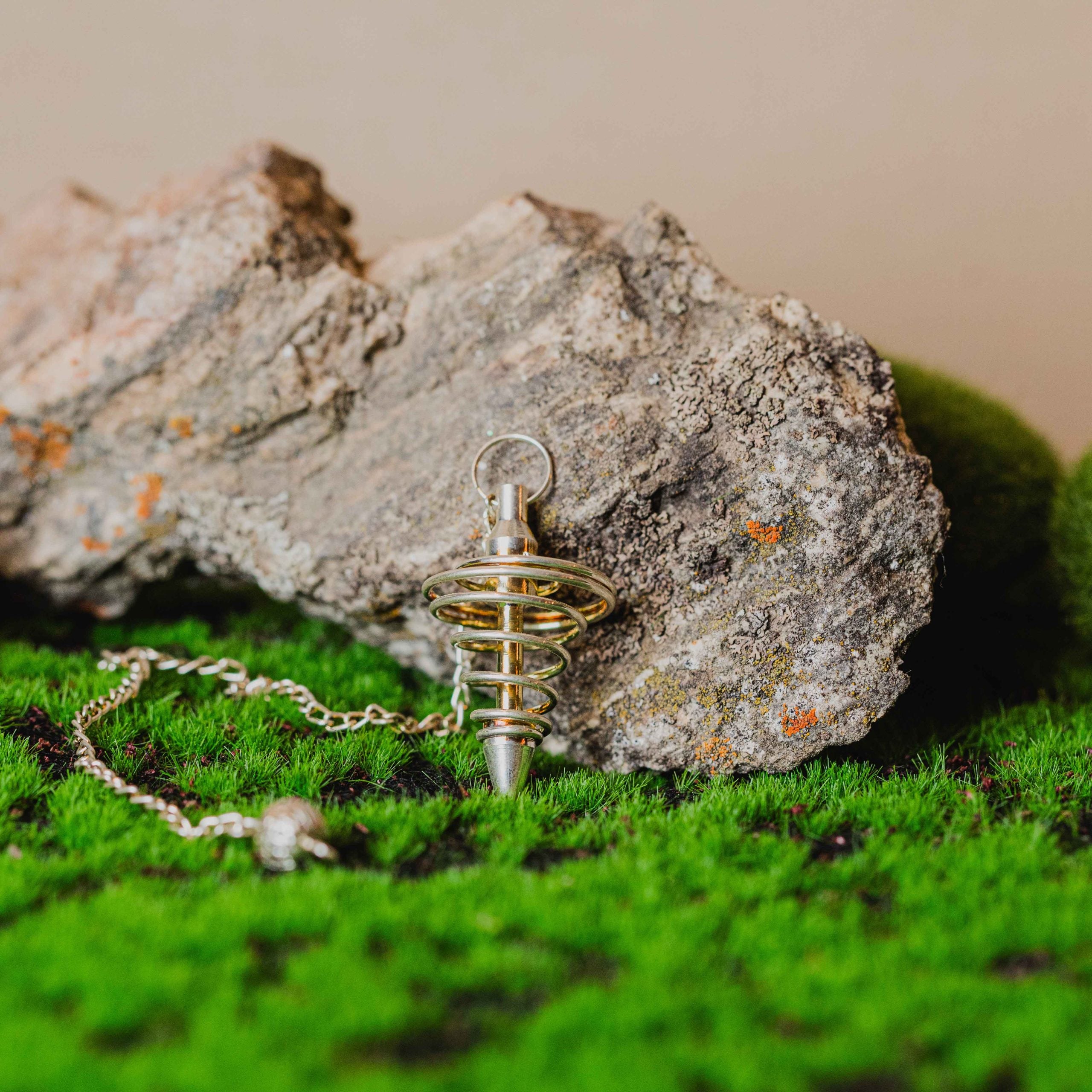 El péndulo metal espiral es con cadena. Las piezas que se entregan son similares a las de la fotografía. Tamaño: de 4 a 6 cm.